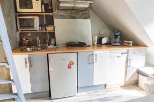 una piccola cucina con armadi bianchi e lavandino di Honfleur location a Honfleur