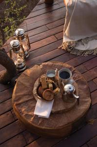 bandeja de comida en una mesa en una terraza de madera en Madikwe Hills Private Game Lodge en Madikwe Game Reserve