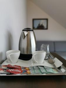 ein Tablett mit einer Teekanne und Tassen auf einem Tisch in der Unterkunft Miodowe Siedlisko in Sokółka