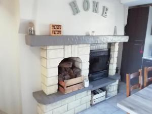 a brick fireplace in a living room at LE GITE DE LA MAISON ROUGE in Anctoville