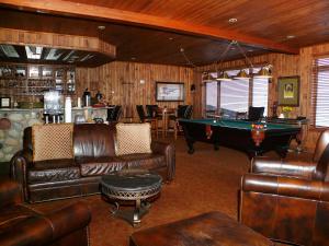 sala de estar con muebles de cuero y mesa de billar en Christie Club, en Steamboat Springs
