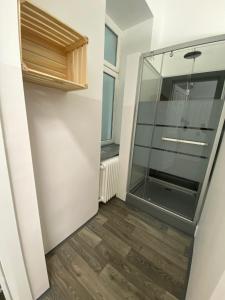 szklanymi drzwiami prysznicowymi w pokoju z drewnianą podłogą w obiekcie Space Home Apartment - Central Station # Hauptbahnhof w Wiedniu