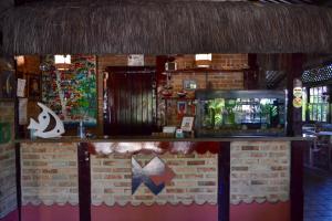 a bar in a restaurant with a fish tank at Pousada do Roballo in Arraial d'Ajuda