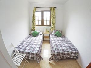 two beds in a room with a window at Casa El Cercado in Santa Cruz de Tenerife