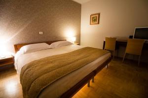 a bedroom with a bed and a desk with a computer at Primula Accommodation in Nova Gorica