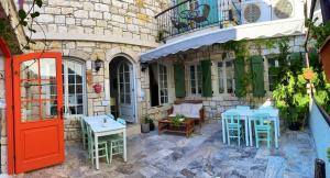 a patio with tables and chairs and a red door at Oberj d'Azur Alaçatı in Alaçatı