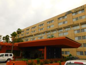 a large building with a red roof and windows at Hotel Palacio Azteca in Tijuana