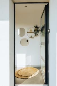 uma porta de vidro que dá acesso a um quarto com um espelho em La Villetta S Blotzheim - Appartement de Standing em Blotzheim