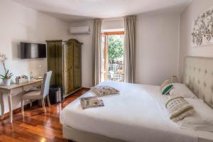 a bedroom with a bed and a desk and a window at Plaza Rooms Ciampino in Ciampino
