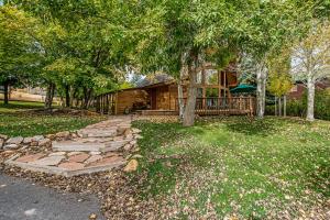 ein Haus mit einem Baum und einem Steinweg in der Unterkunft Aspen Hideaway Cabin in Garden City