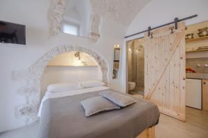 una camera con un grande letto e una porta in legno di CASA FLAMI' a Ostuni