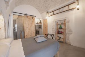 a room with a bed, a table and a wall at CASA FLAMI' in Ostuni