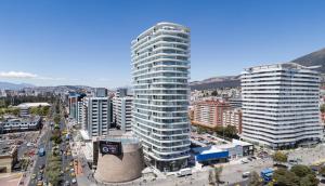a tall building in a city with a street at Suite Apartamento Espectacular Vista La Carolina - ONE Quito in Quito