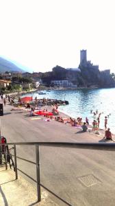 a group of people on a beach near the water at With Love in Malcesine