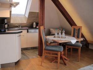 a kitchen with a table and chairs with bottles on it at Pension Refugium überm Schwansee in Weimar