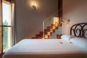 a bedroom with a white bed and a staircase at Las Casitas de la Data in Gallegos