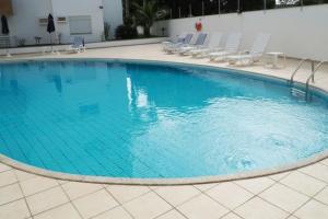 uma grande piscina com espreguiçadeiras em Repouso Gaivotas em Florianópolis