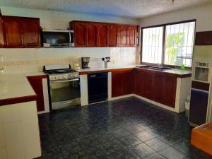 a kitchen with wooden cabinets and a stove top oven at La Quinta de Don Hugo in Ixtapa