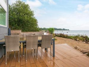 een terras met een tafel en stoelen op het strand bij 6 person holiday home in Haderslev in Haderslev