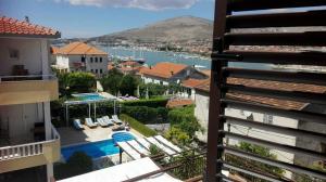 a view of a house with a swimming pool and a city at Fresh Apartments Dar Orlic in Trogir