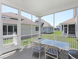a patio with a table and chairs on a deck at Bayside Resort - 36477 Wild Rose in Selbyville