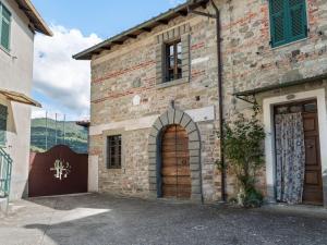 Casola in LunigianaにあるAncient Farmhouse with private heated hot tub and poolの木製のドアのある大きなレンガ造りの建物