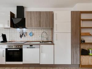 a kitchen with white cabinets and a sink at Apartment on the edge of the forest in Kleines Wiesental