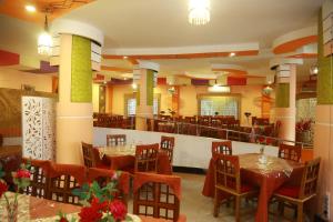 un ristorante con tavoli e sedie in una stanza di Hotel Farmis Garden a Sylhet