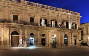 un gran edificio de piedra por la noche en B&B Conte Ruggero, en Scicli