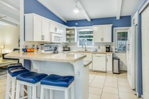 a kitchen with white cabinets and blue walls at Au Soleil in Anna Maria