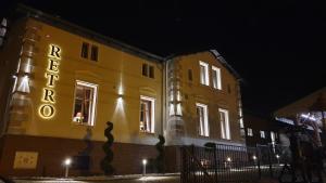 een geel gebouw met 's nachts een bord bij Restauracja RETRO & OAK ROOMS in Oborniki Śląskie