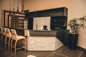 a kitchen with a bar with chairs and a plant at OP'S HOTEL in Serranópolis
