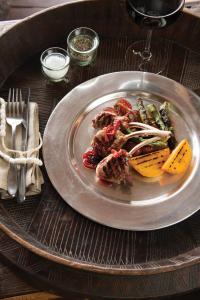 a plate of food with meat and vegetables on a table at Madikwe Hills Private Game Lodge in Madikwe Game Reserve