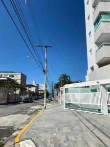 an empty street with a white fence and a building at AP 71 COSTA VERDE PRAIA GRANDE in Praia Grande