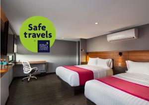 a hotel room with two beds and a sign that reads safe travels at Hotel MX aeropuerto in Mexico City