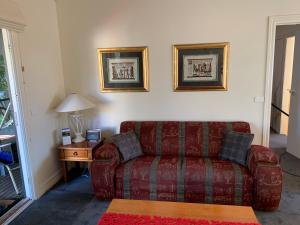 a living room with a red couch and a table at Weeroona Bed And Breakfast in Rye