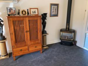 a room with a wood stove and a dresser at Weeroona Bed And Breakfast in Rye