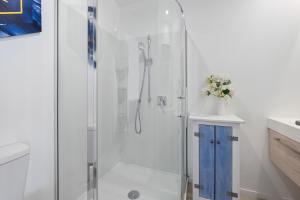 een douche met een blauwe kast in een badkamer bij Brookside Gem - Modern 2 Bedroom Apartment in Queenstown