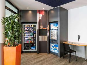 a kitchen with a refrigerator filled with drinks at ibis budget Marne la Vallée Val d'Europe in Montévrain