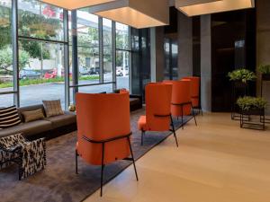 a lobby with orange chairs and a couch at Mercure Sao Paulo Barra Funda in São Paulo