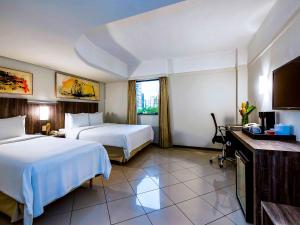 a hotel room with two beds and a television at Grand Mercure Belem do Para in Belém