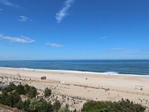 a beach with people on the sand and the ocean at Sea Colony Farragut House III in Bethany Beach