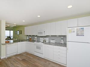 a kitchen with white cabinets and a white refrigerator at Sea Colony Edgewater House VI in Bethany Beach