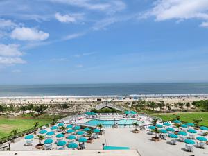 an aerial view of a pool and beach with umbrellas at Sea Colony Edgewater House VI in Bethany Beach