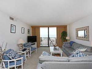 a living room with blue and white furniture and a balcony at Sea Colony Annapolis House II in Bethany Beach