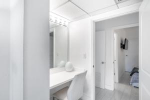 Baño blanco con lavabo y espejo en Sunny Isles Ocean Reserve Superb Condo Apartments en Miami Beach