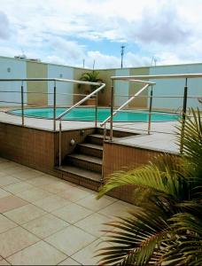a building with a swimming pool with stairs next to it at Hotel Saint Paul 01 Flat in Manaus