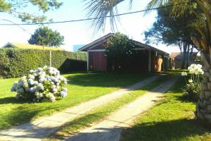 uma casa com um quintal com uma casa com flores em Casa chalet en Solanas Portezuelo Punta ballena em Punta del Este