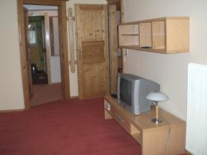 Zimmer mit TV auf einer Kommode mit Tür in der Unterkunft Haus Alpenglühn in Abtenau