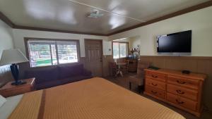 a bedroom with a bed and a flat screen tv at Kernville Inn in Kernville